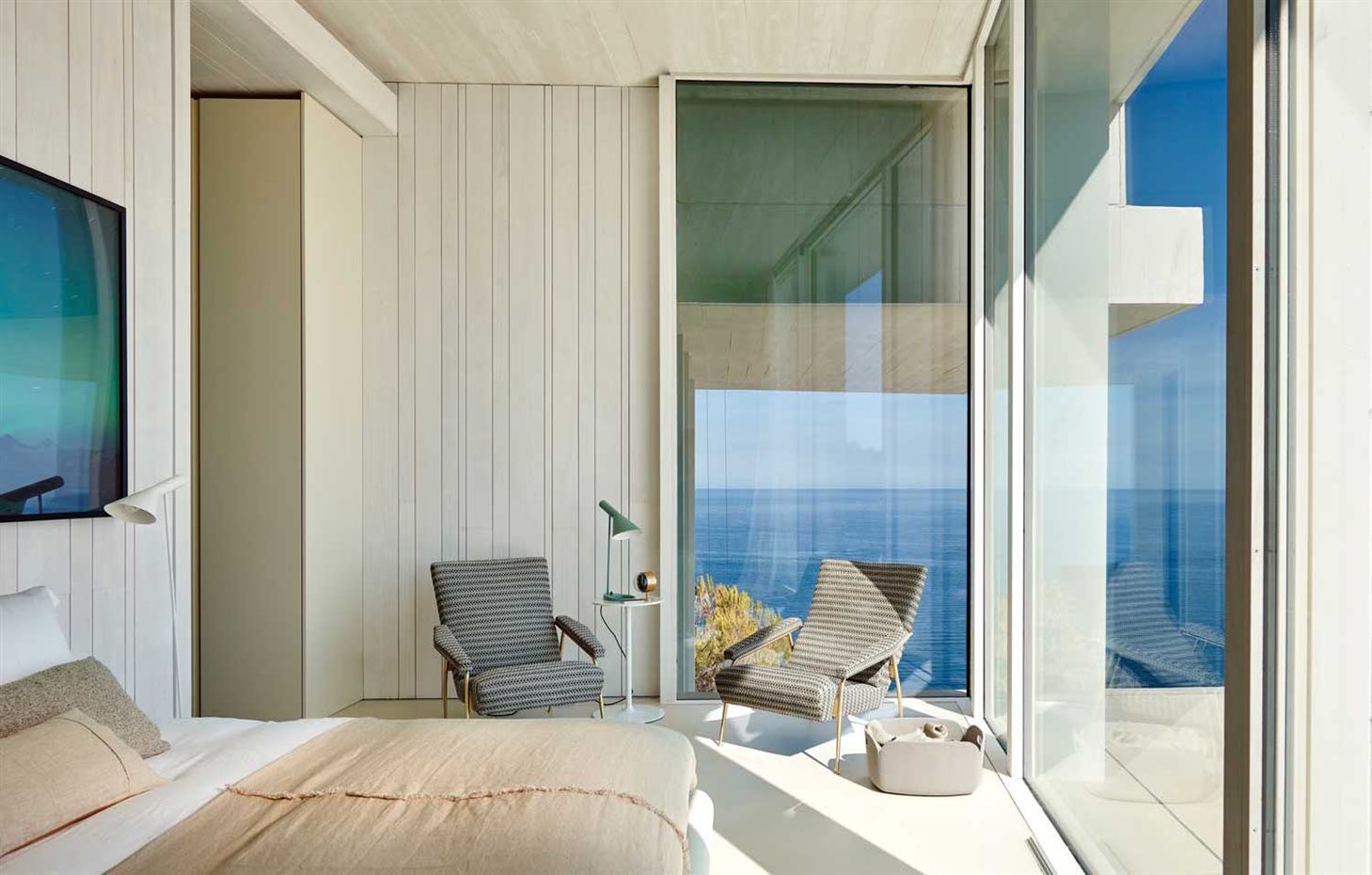 3. Cada habitación cuenta con un pequeño balcón de vidrio a modo de mirador. La cama es de Living Divani. Butacas, modelo D.153.1, diseño de Gio Ponti para Molteni&C. Reloj-despertador, de Vitra. La cesta de fieltro es de la firma Muuto