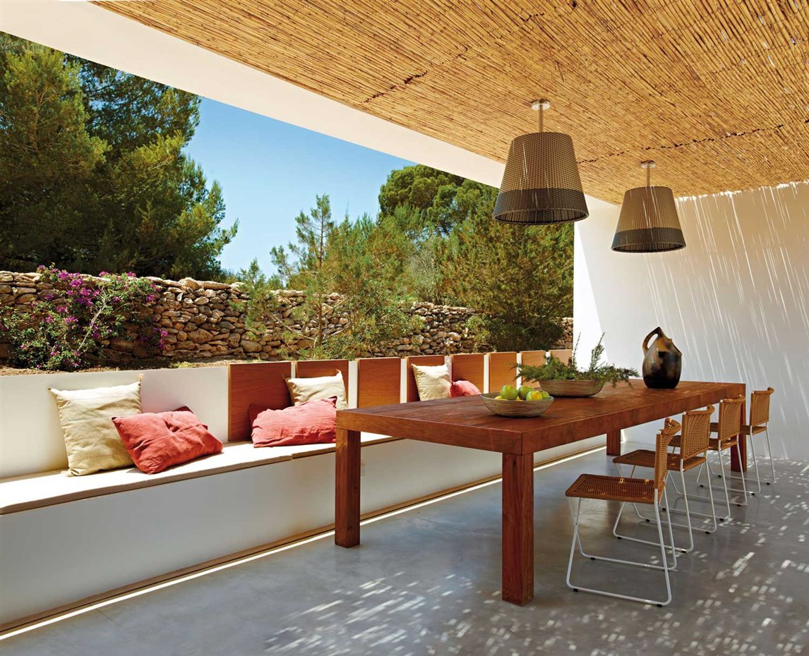 00345969. En el porche, mesa diseñada por Estudio Marià Castelló y realizada en madera de iroco por Como...da. Sillas Ramón, de Ramón Bigas para Santa & Cole. Lámparas, modelo Romeo, de Philippe Starck para Flos