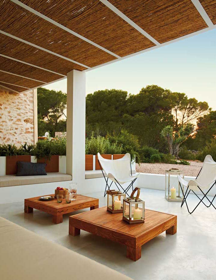 5. Las pérgolas, con estructura de acero y paneles de caña, tamizan la luz de Formentera y ofrecen reconfortante sombra. las mesas bajas del porche son un diseño de Estudio Marià Castelló realizado por Como...da
