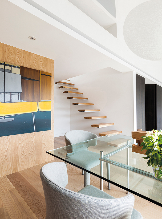 aticoe23. Las sillas Hola son un diseño de Hannes Wettstein para Cassina. Mesa de comedor LC12, de Le Corbusier y Pierre Jeanneret, editada por Cassina. La escalera conduce a la zona privada de la casa, donde se encuentra  la suite y el estudio.