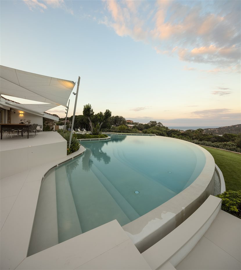 309. La piscina, proyectada en el frente principal de la casa para crear una escenografía entre el cielo y el mar, se caracteriza por el diseño fluido, a la vez que geométrico y racional, que cubre 230 m²