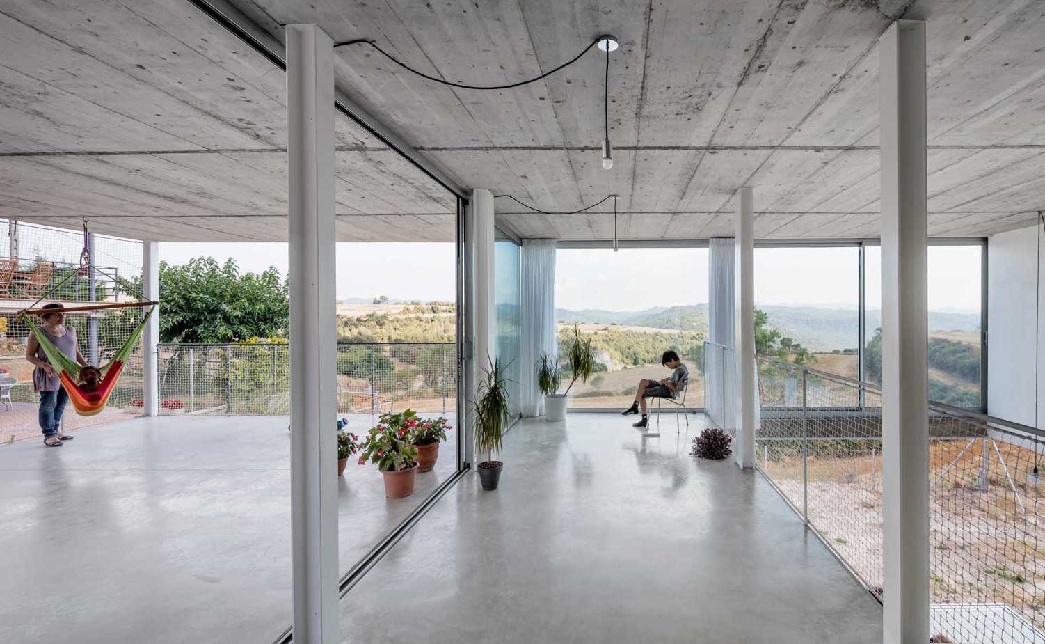  AG 0590+91. ligereza formal se consigue mediante una estructura de losas de hormigón horizontales y pilares de acero que liberan el espacio y eliminan las particiones, creando continuidad visual y límites diluidos