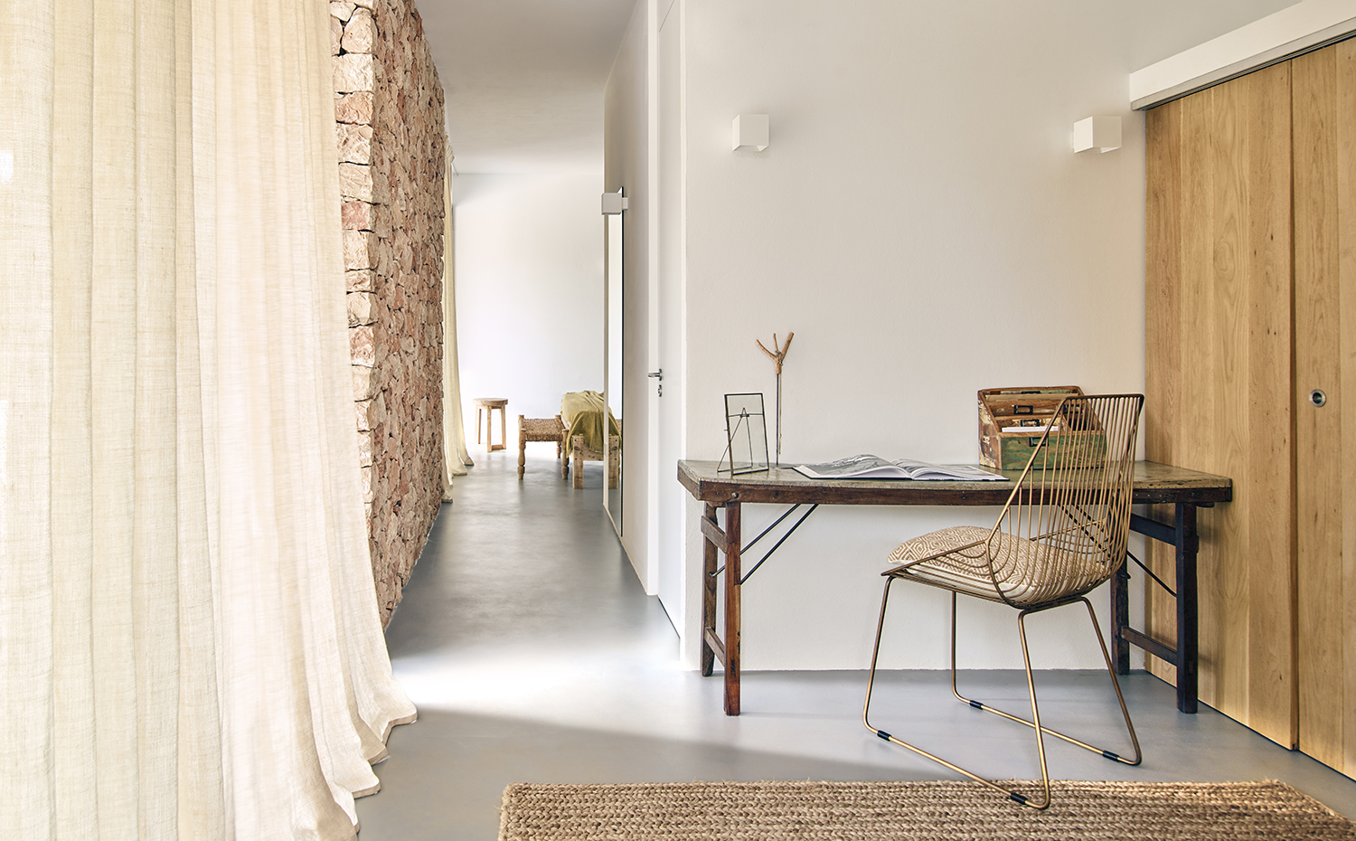 00433090. Los muros de mortero de cemento se han pintado de blanco mate para potenciar los efectos de la luz natural en el interior. El rincón de trabajo se ha equipado con una mesa de madera comprada en Can Xieu y una silla de la tienda Rocket St. Georges de Londres