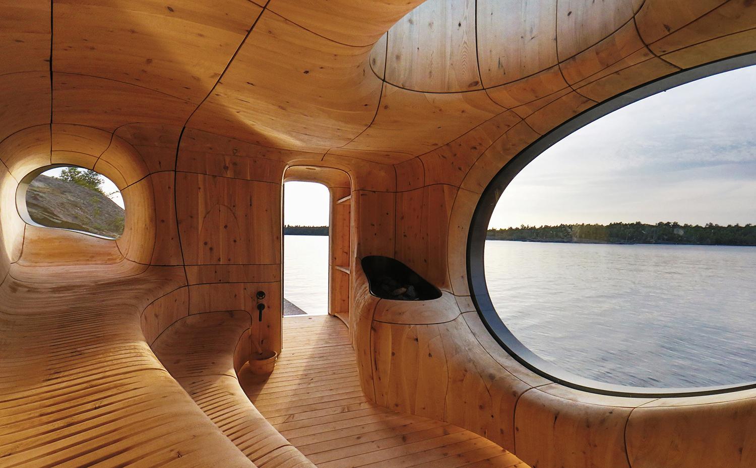 grotto-partisans-hero. El estudio canadiense Partisans escogió un concepto de contrastes para la Grotto Sauna en el norte de Toronto (Canadá), de presencia sólida y austera en su exterior, y de geometría orgánica en el interior. El resultado es un espacio esculpido, una experiencia sensual frente al lago