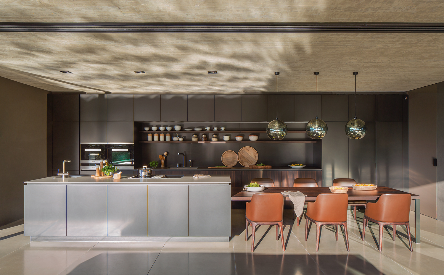 MFP22422. El mobiliario de cocina es el modelo Artex y la mesa de comedor, la Dart; todo de Varenna Poliform. Electrodomésticos, de Gaggenau y Míele, y griferías, de Dornbracht y Atlas. Sillas, modelo Grace, de Enmanuel Gallina para Poliform