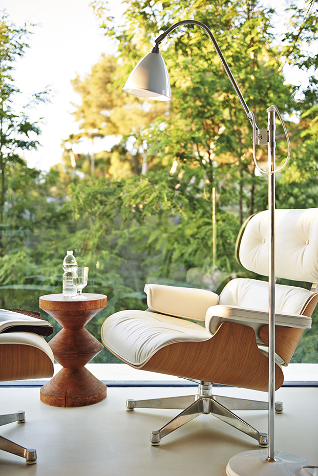 00384469. La butaca de piel, con otomana, es la Lounge Chair, de Ray y Charles Eames, editada por Vitra. El taburete torneado, de madera de nogal, es también un diseño de los Eames, editado por Vitra, que puede utilizarse como mesita auxiliar