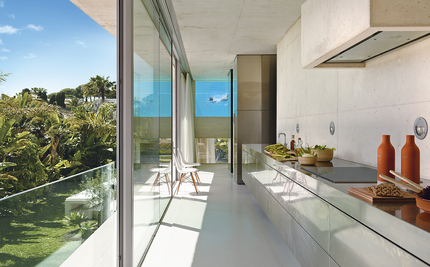00384472. La cocina, situada a lo largo de la fachada sur en el primer nivel, tiene todos los electrodomésticos integrados en un pasillo adyacente y perpendicular a ella. El mobiliario es un diseño del estudio de arquitectura, fabricado con acero inoxidable