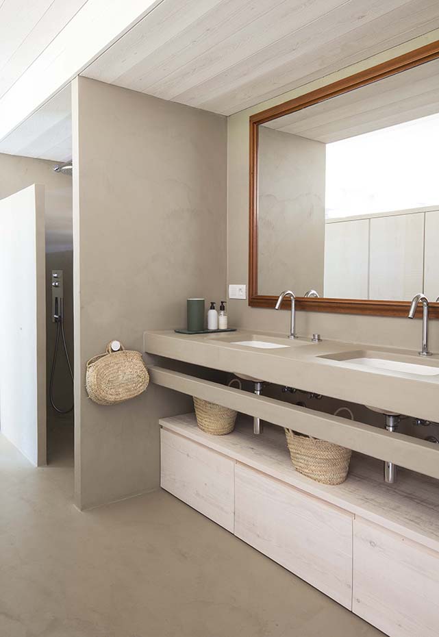 Residencia Ampurdán 3 Bárbara Aurell. El suelo se ha revestido con microcemento color tierra del Ampurdán. En el baño se prolonga en los tabiques que delimitan la ducha de la zona de lavamanos