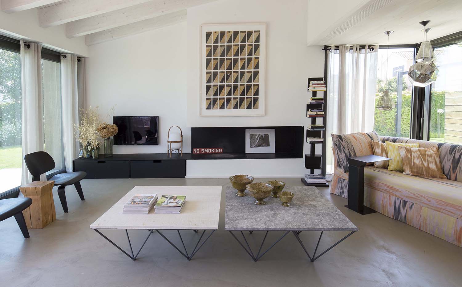 Residencia Ampurdán12 Bárbara Aurell. Los propietarios de esta casa son grandes apasionados del arte. La chimenea de hierro forjado está presidida por un cuadro de Bruno Ollé de grandes dimensiones. A la izquierda, sillas DCW Plywood Chair, diseño de los Eames que edita Vitra