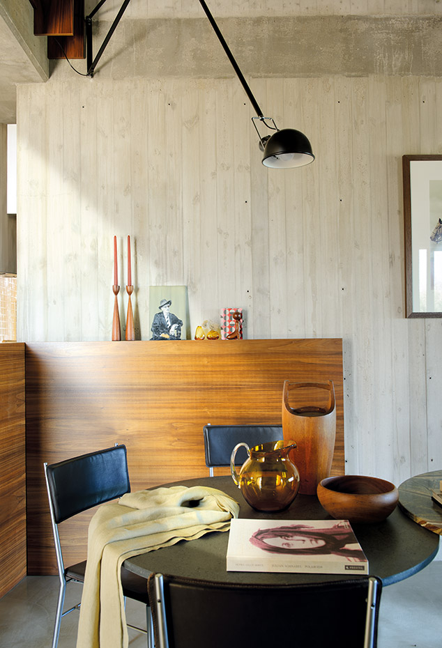 066 DSC9477. La mesa, con sobre de piedra de lava, es un diseño de PCA, hecha por artesanos locales. Sillas, de Mike Stoner. Lámpara 265, de Paolo Rizzatto para Flos. Los objetos de madera son diseños daneses de los años cincuenta