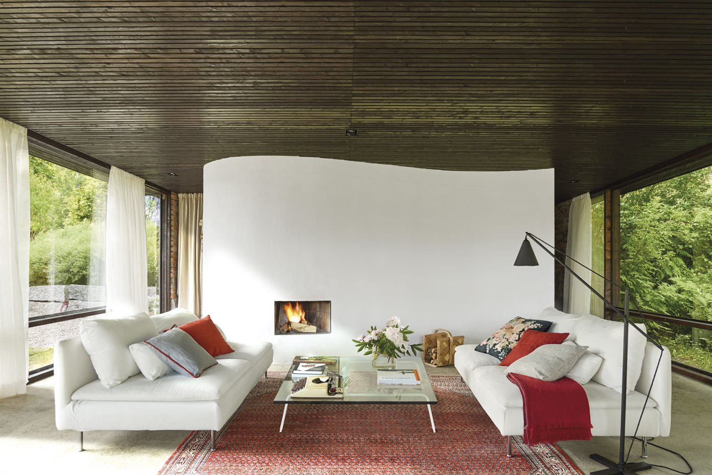 930-AyD-Delin,B.-Ludnas-02. El mobiliario, los colores y el paisaje crean un interior optimista y cálido. La chimenea, un hueco con marco abierto en el muro, es un diseño de Buster Delin. Focos de techo Atlanta Trimless