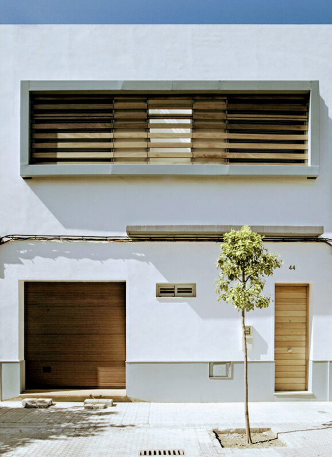 08,A.Topete,U+G. La fachada de estuco de cal blanco, un material autóctono, integra la vivienda en el entorno a la vez que hace destacar el gran ventanal rectangular en la parte superior
