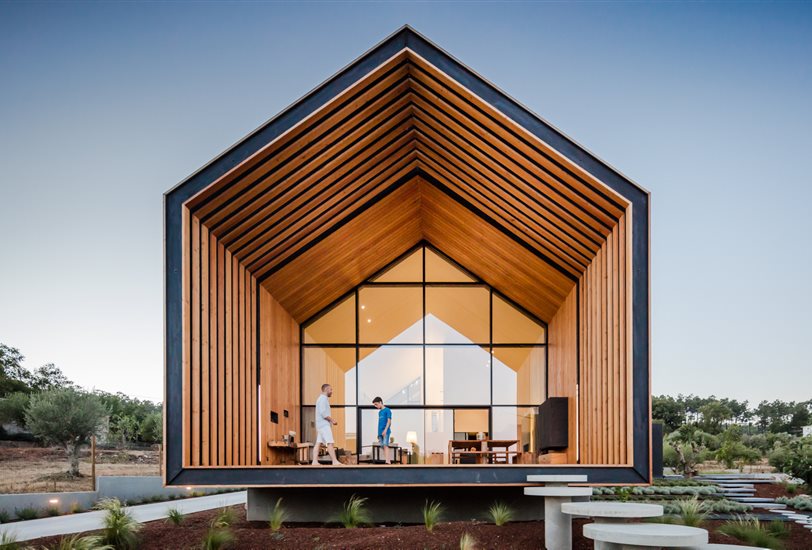 La casa resulta en un volumen simple y perfectamente regular, casi monolítico, que aterriza en el suelo para crear un mirador desde el porche frontal que mira por encima del jardín.