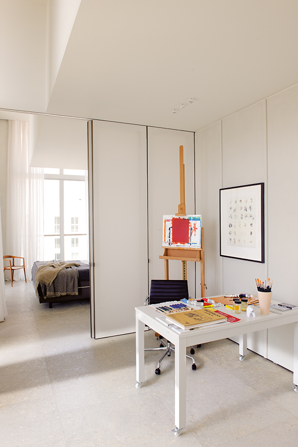 054 DSC4149. La habitación que se utiliza como taller de pintura comunica con el dormitorio a través de puertas correderas y aprovecha la luz natural que entra por la ventana de este. La mesa, lacada de blanco y equipada con ruedas, se ha hecho a medida. En el suelo, piedra de Italia.