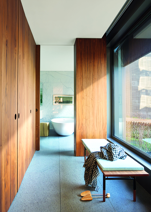 AyD-KoganBCN-11. la piel interior de esta vivienda de 600 metros con algunas de las referencias más exclusivas: el nogal americano se yuxtapone a mármoles Estatuario, Carrara, Bamboo y Negro Marquina, piedra Basaltina Romana –en el suelo– y latón. Banco, de Finn Juhl, adquirido en MINIM. 