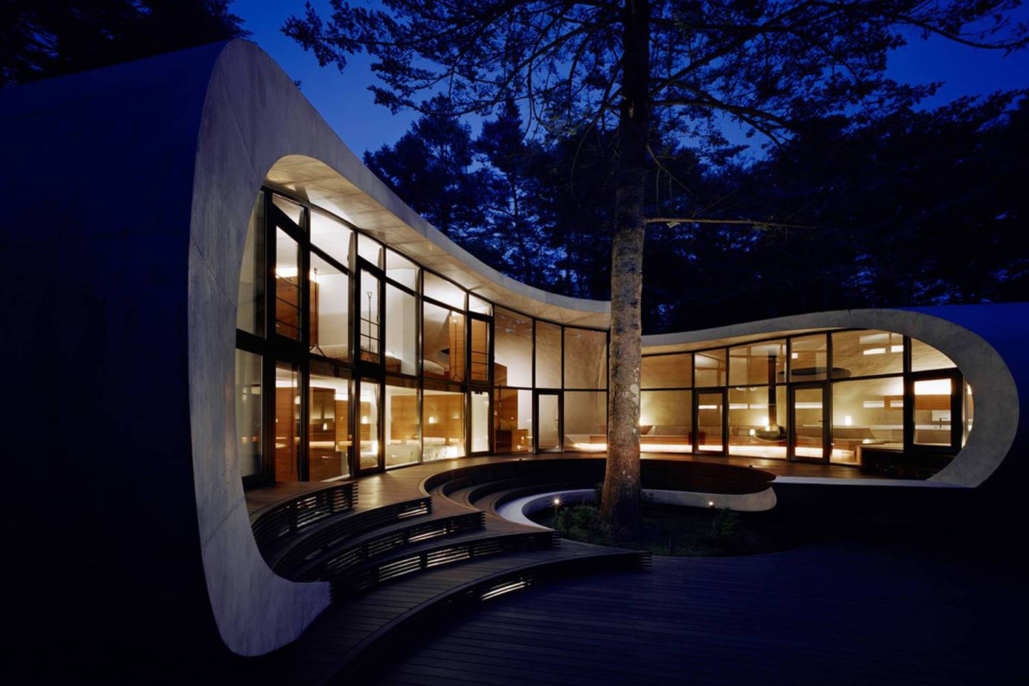 El estudio japonés ARTechnic Architects diseñó la envolvente de la casa Shell como una gran cáscara sinuosa que se pliega para encerrar espacios y generar porches.
