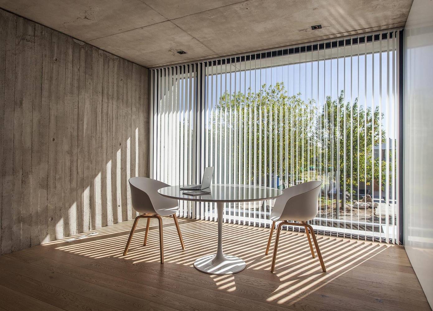 Casa MF Estudio V2 Arquitectos Arquitectura y Diseno 15. En el piso superior encontramos un pequeño rincón de trabajo junto a una ventana. Las lamas que los arquitectos han incorporado a las ventanas permiten tamizar la luz de forma sencilla y eficiente.