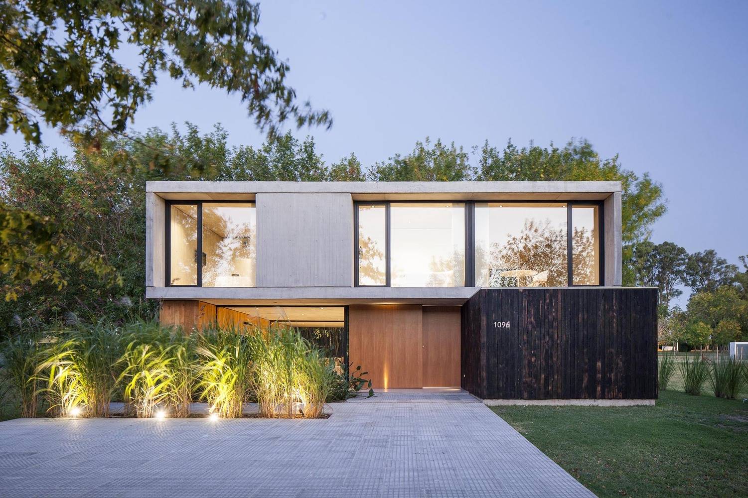 Casa MF Estudio V2 Arquitectos Arquitectura y Diseno 17. La estructura base se ha conformado a partir de hormigón, madera y vidrio, elementos presentes en la fachada principal.