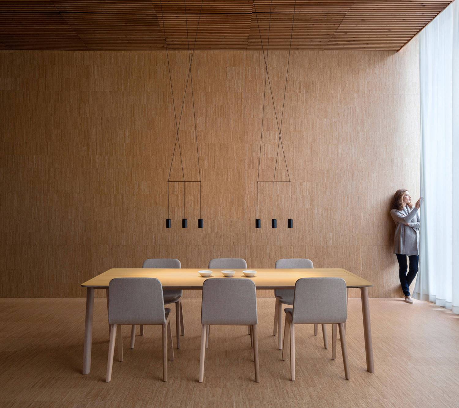 Espacio de comedor iluminado con luminarias Wireflow Lineal, de Vibia.
