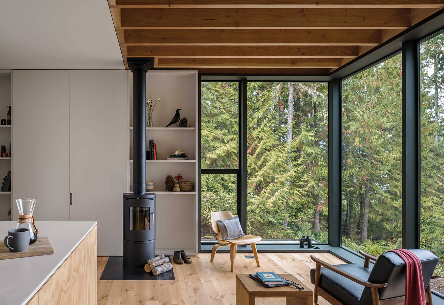 Interior con cálida estructura, suelo y mobiliario de madera vista.