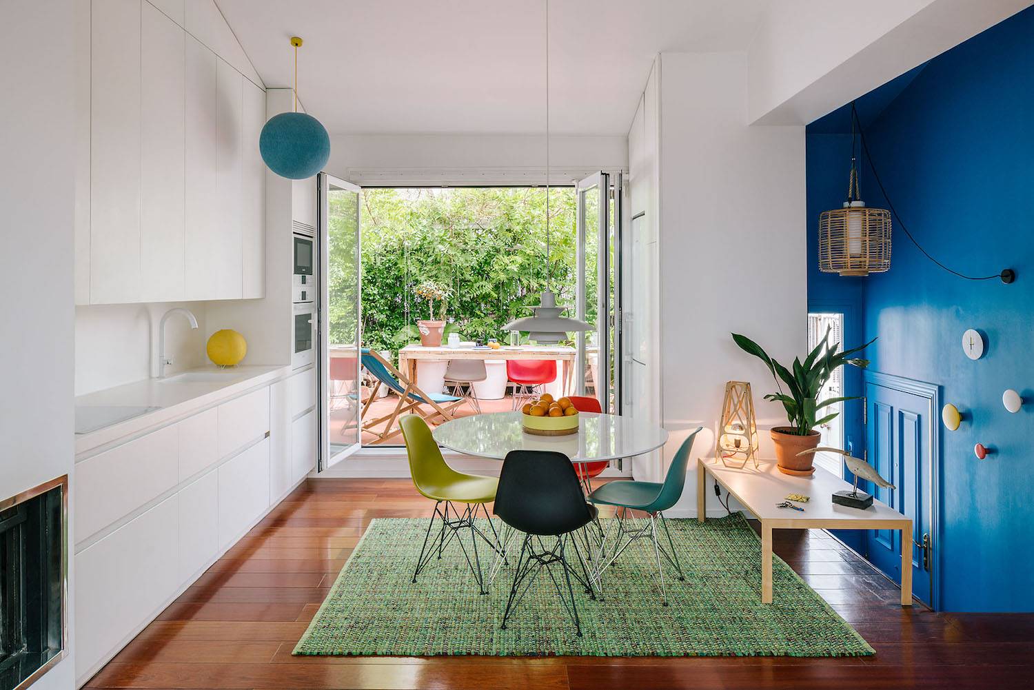La cocina con vistas a la terraza. La cocina con vistas a la terraza, disfruta de una preciosa luz natural que se ve complementada por la lámpara de suspensión que Poul Henningsen diseñó para Louis Poulsen