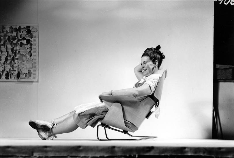 Ray Eames sentada en un prototipo de silla