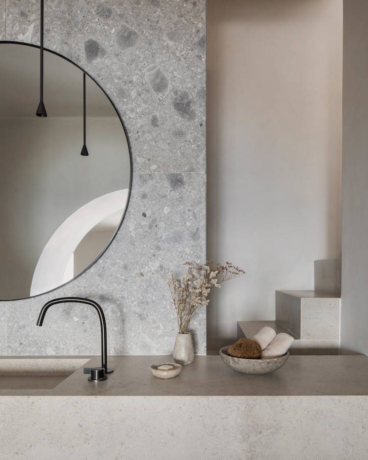 Espejo y fregadero de baño de las villas en Santorini. Detalle de uno de los baños de las villas cuyas superficies y materiales pulidos, hacen que la grifería se aprecie de un modo muy orgánico.