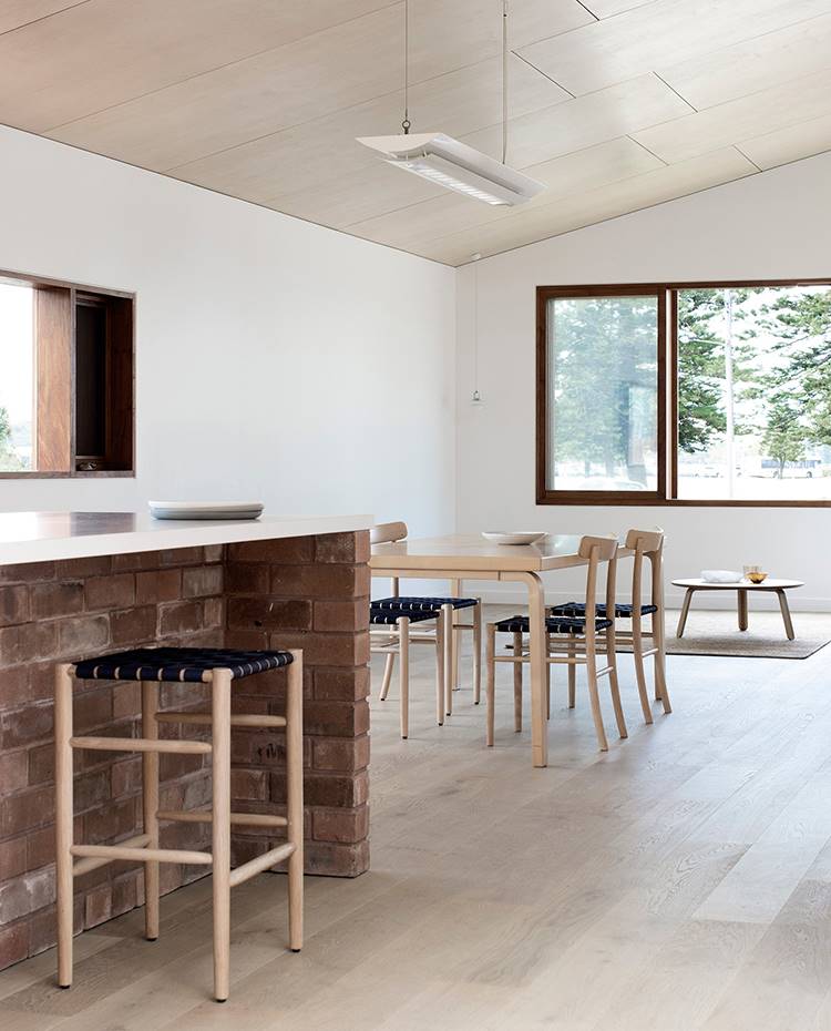 Zona de día abierta, taburete office, mesa de comedor con sillas. La cocina, el comedor y el salón ocupan un mismo ambiente diafano de planta rectangular donde la isla de ladrillo visto donde se emplaza la zona de office atrae las miradas.