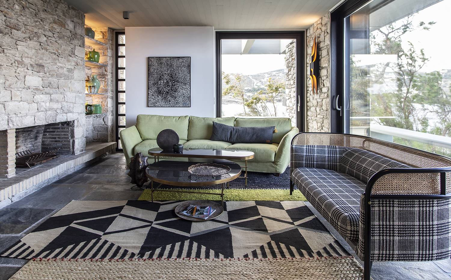 casa kettal grecia 02 salon sofa chimenea piedra alfombra. El sofá verde es el modelo Viktoria, de SITS. Mesa de centro Nelson A, de Frigerio. Alfombra, de GAN Rugs