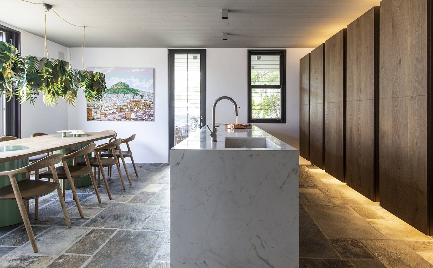 casa kettal grecia 09 cocina integrada isla iluminacion. La isla de cocina, revestida con mármol griego, es un diseño de Katerina Veremi Xynogala, la misma creadora de los armarios suspendidos, con acabado en roble de la firma española MH Parquets.