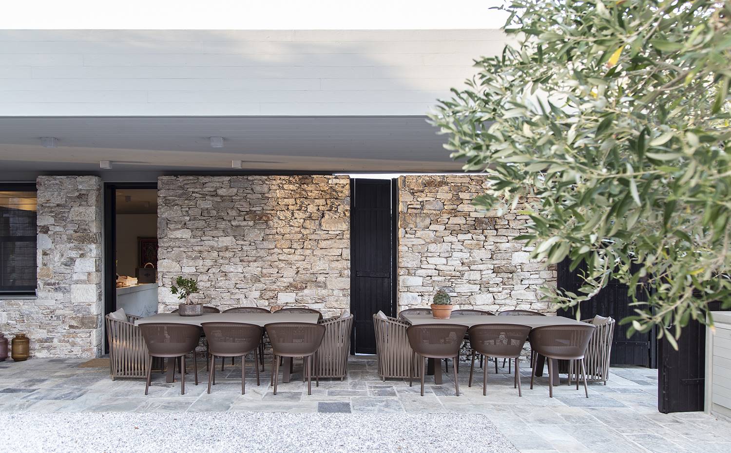 casa kettal grecia 11 terraza mobiliario exterior piedra. El comedor exterior se ha amueblado con mesas de la colección Vieques, de Patricia Urquiola, y sillas Stampa, de los Bouroullec, y Bitta Lounge, de Rodolfo Dordoni. Todo es de Kettal