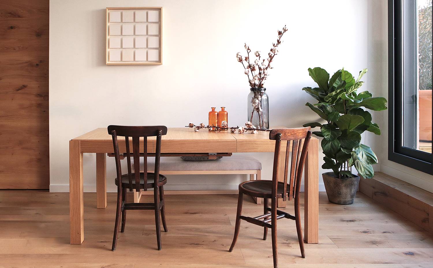 Comedor, mesa rectancgular madera, suelo de madera, sillas retro, banco corrido. Piezas antiguas y modernas se combinan con acierto en los diferentes ambientes de esta vivienda barcelonesa donde impera la calidez y la funcionalidad.