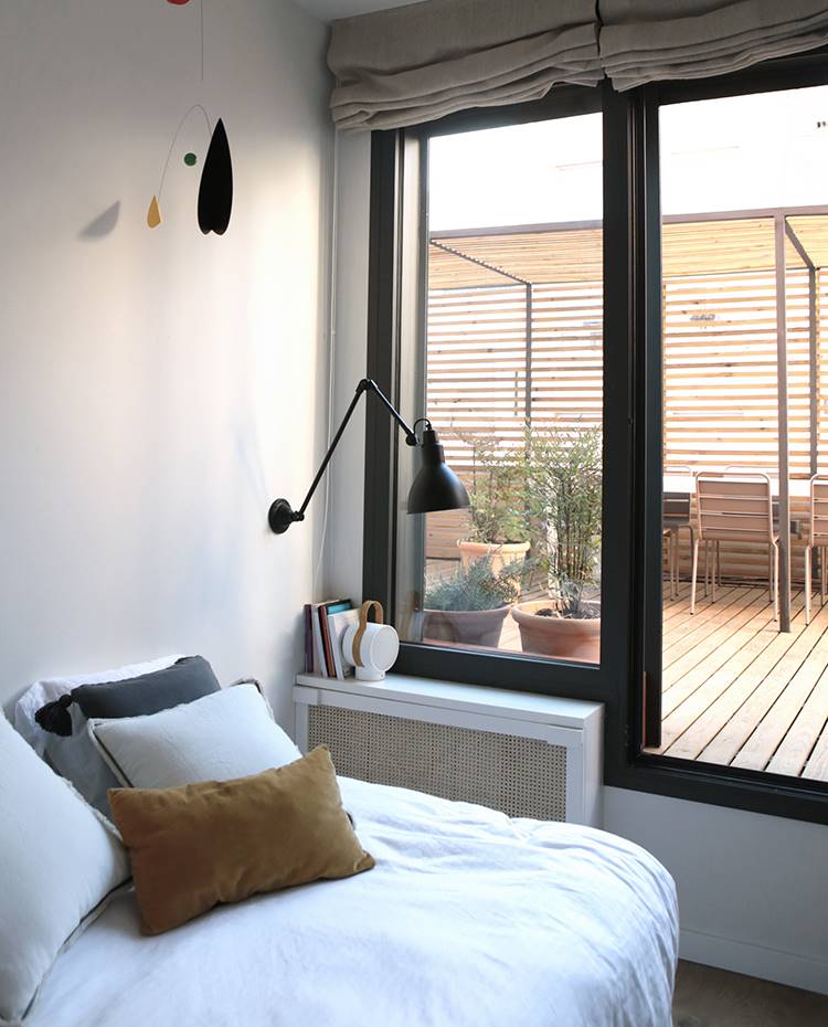 Dormitorio, cojines sobre cama, cerramiento acristalado, terraza exterior celosias. Se ha potenciado la iluminación natural volcando todas las estancias a la terraza pero sin comprometer la privacidad a través de un juego con las celosías y la vegetación.