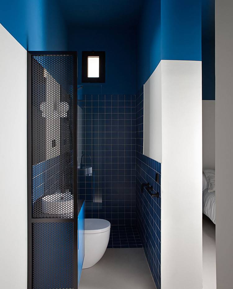 Ban��o abierto a dormitorio, tabique abierto, revestimiento azul, mobiliario azul. La habitación azul y beige es la más pequeña de la casa, por ello tenía que tener algo más. El baño privado tiene los mismos colores que el espacio que se refleja a través del espejo situado en la zona de tocador. 