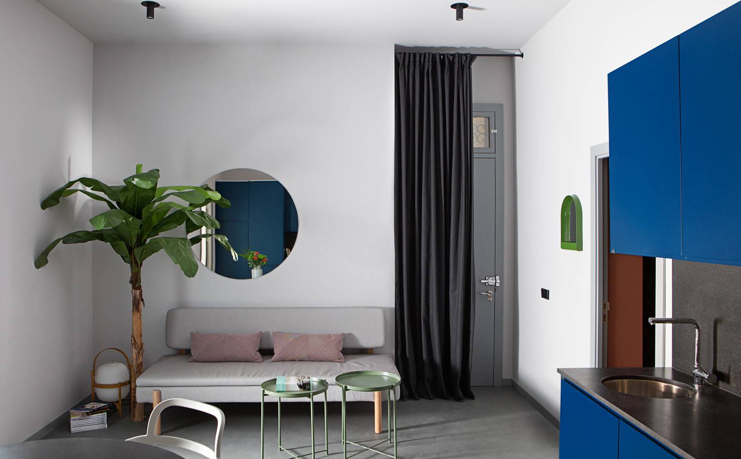 Salón-comedor, cocina integrada, mesas auxiliares verdes, cocina azul, contina frente a entrada. Cada habitación ha sidotratada como un proyecto individual y el mayor desafío se ha basado en tener seis espacios muy diferentes que conviven en armonía en un apartamento singular.