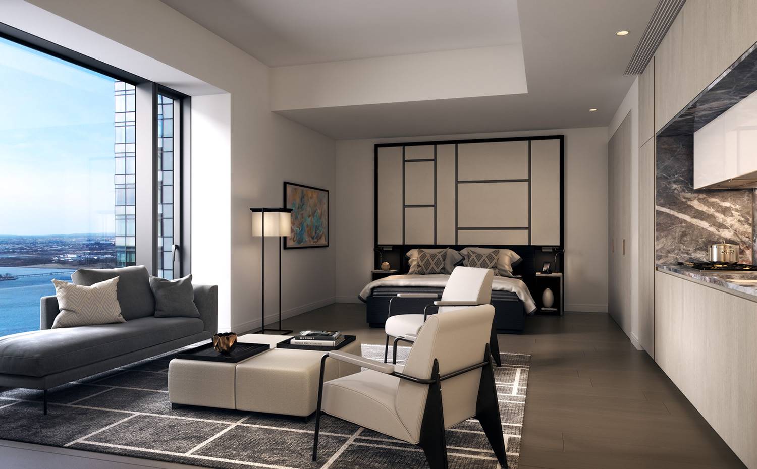 Dormitorio con cocina, chaise-longue frente a apertura, butacas blancas, mesa a modo de puf. El dormitorio, junto con el resto de estancias de la vivienda está equipado con mobiliario hecho a medido y asientos y acabados en una constante cromática inspirada en el paisaje exterior.
