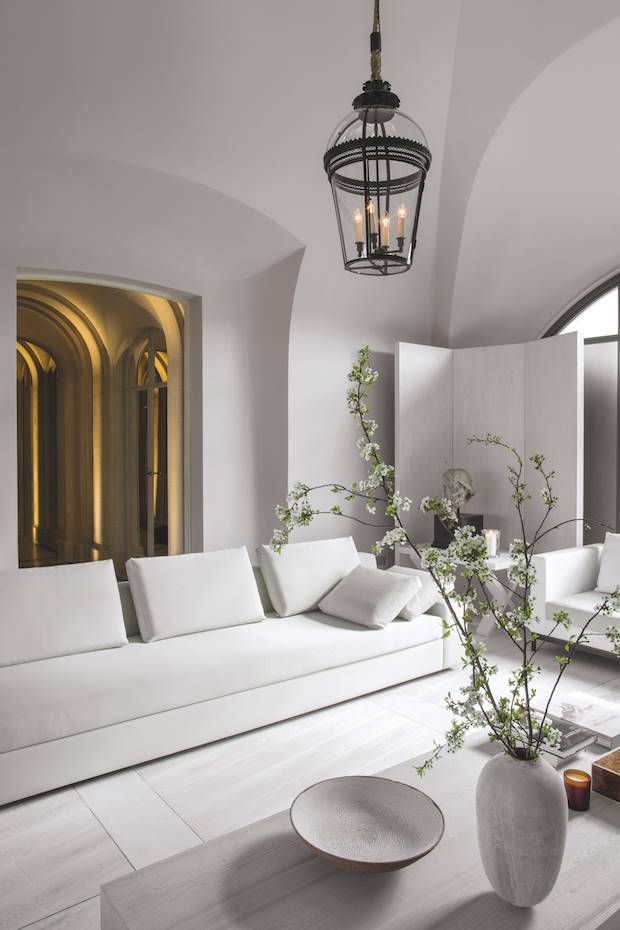 Salon con sofa blanco y techos con arcos de un apartamento en Paris. La sala de estar expresa el estilo atemporal y sosegado de Guillaume Alan: la forma en que trata y define el espacio es muy limpia, tiene un enfoque puro e impecable del espacio. Los sofás y la mesa de centro son de la colección Satin, de Guillaume Alan.