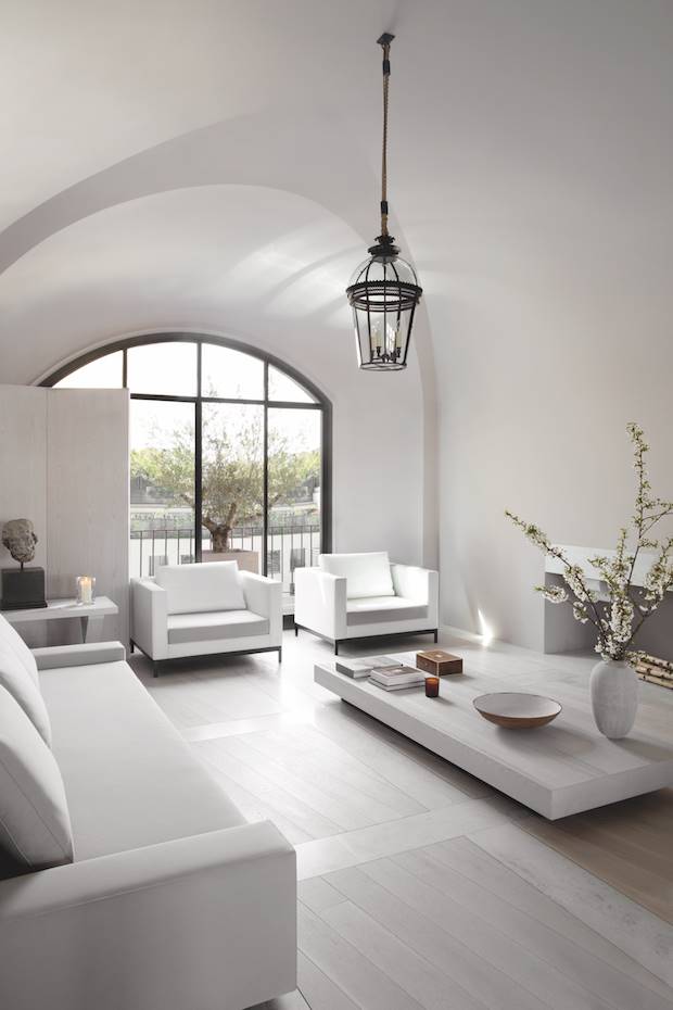 Salon de color blanco con arcos y molduras de un apartamento en Paris. El ventanal se ha inspirado en una antigua puerta que Alan vio en Oxford, mientras que el techo abovedado magnifica la altura del espacio. Siguiendo un alto nivel de precisión, las franjas de mármol se cruzan entre sí en el suelo en contraste con la tarima de madera de roble