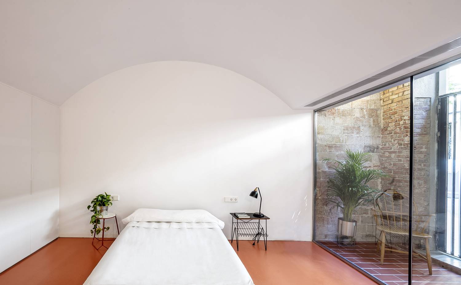 Dormitorio doble, bóveda techo, cerramiento acristalado. Predomiantemente blanco y puro, el dormitorio principal contrasta con las paredes de piedra y el suelo cerámico de la zona de acceso. 