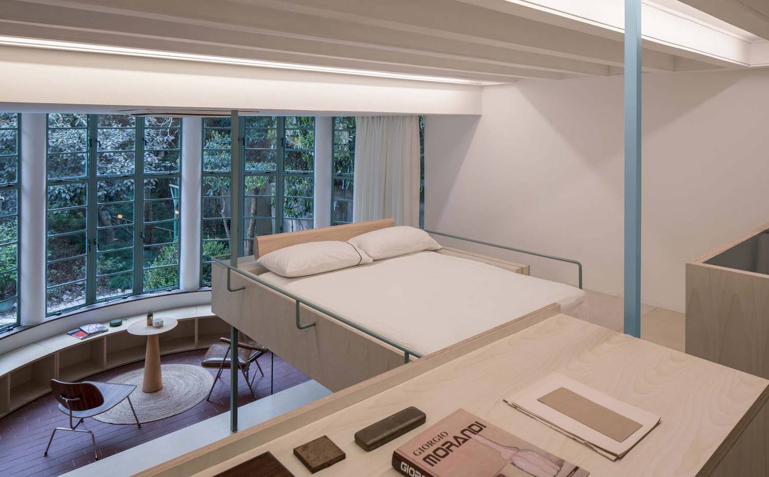 Cama suspendida sobre hueco salón. Para este proyecto, el estudio Atelier tao + c situa la cama en una posición que parece levitar sobre el resto de la vivienda.