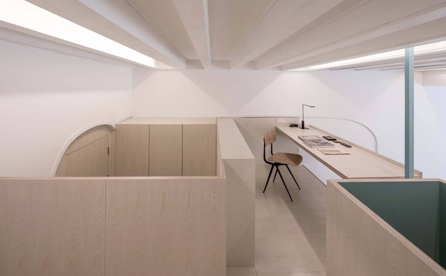 Zona de estudio y almacenaje en el nivel superior. Una estructura de madera contrachapada de arce sirve de elemento organizador de las diferentes áreas de la vivienda, como el estudio situado en el nivel superior.