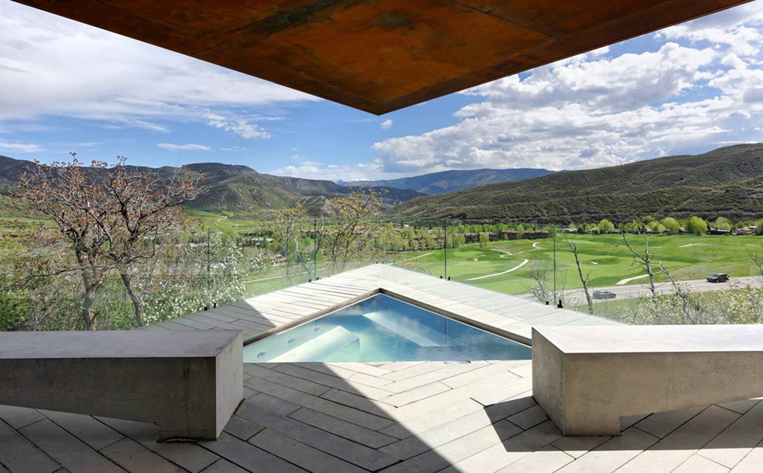 Piscina triangular cubierta en terraza, frente a paisaje de montañas. En la terraza del piso inferior, se emplaza este 'jacuzzi' triangular situado bajo cubierta y con vistas excepcionales del entorno.