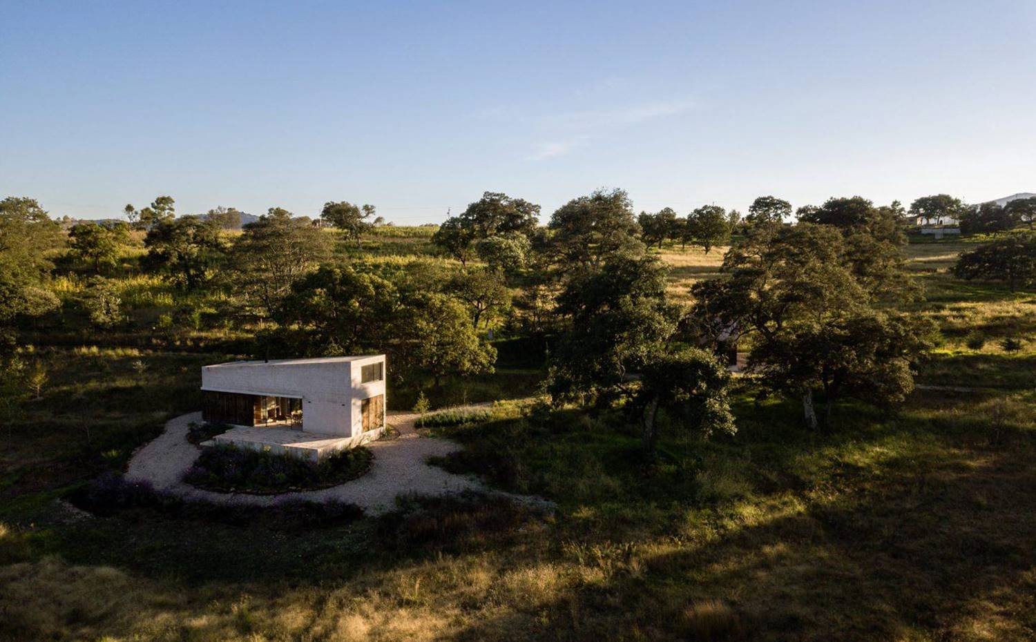 Entorno natural, rodeado de árboles, vista exterior vivienda con cerramientos de cristal y madera.. El poderse escapar de la ciudad y estar "en mitad de la nada", fue el objetivo marcado por los propietarios y desarrollado por PPAA en esta vivienda de 90 metros cuadrados rodeada de naturaleza.