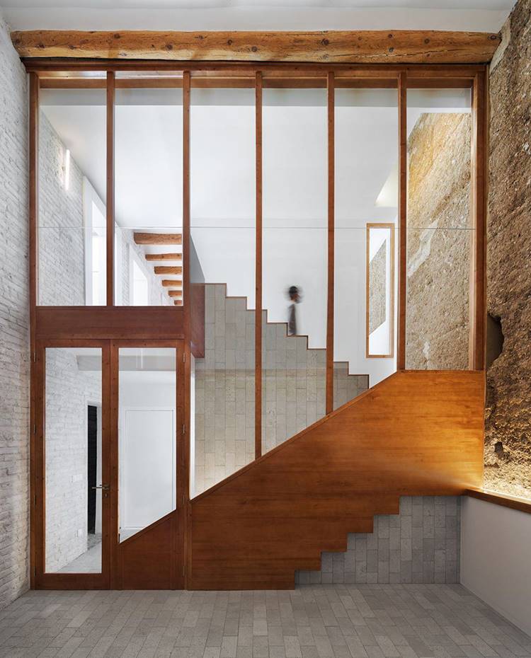 Patio interior vivienda, cerramiento acristalado y detalles madera, escaleras a doble altura. El edificio existente a intervenir es el resultado de la suma de dos casas con medianeras de tapial. Estos edificios responden a la tipología típica de la zona, la plana de Lleida. 