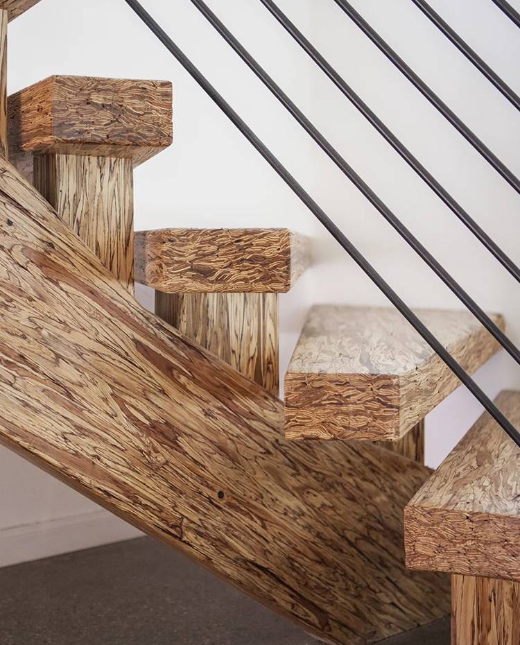 Detalle escaleras circulares de madera con barandilla de acero.. El padre de Greg construyó la casa empleando para la escalera curva de grandes dimensiones madera recuperada. Para el suelo se optó por hormigón.