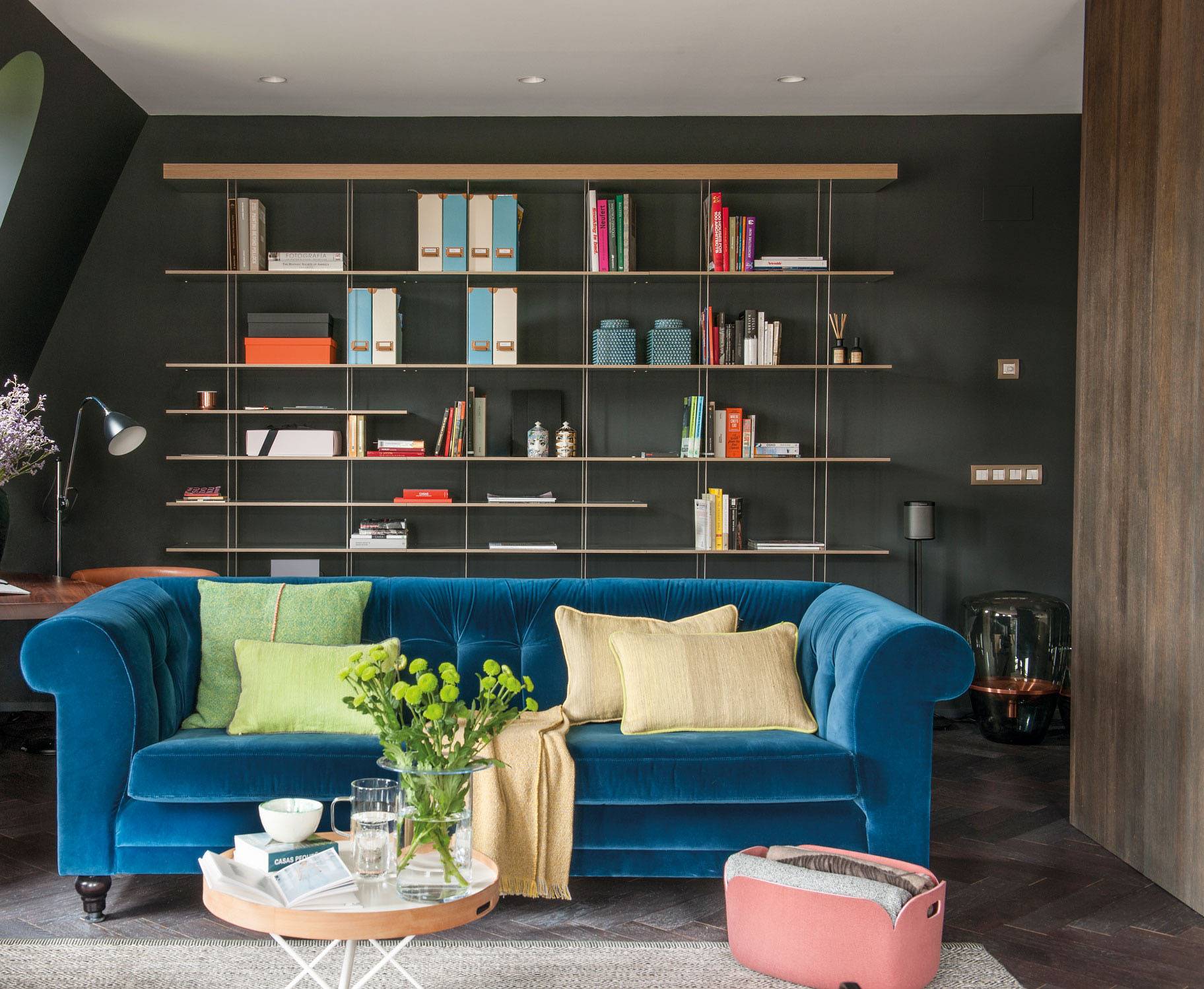salón con sofá de terciopelo azul librería. Usa tejidos sofisticados. Revalorizar piso