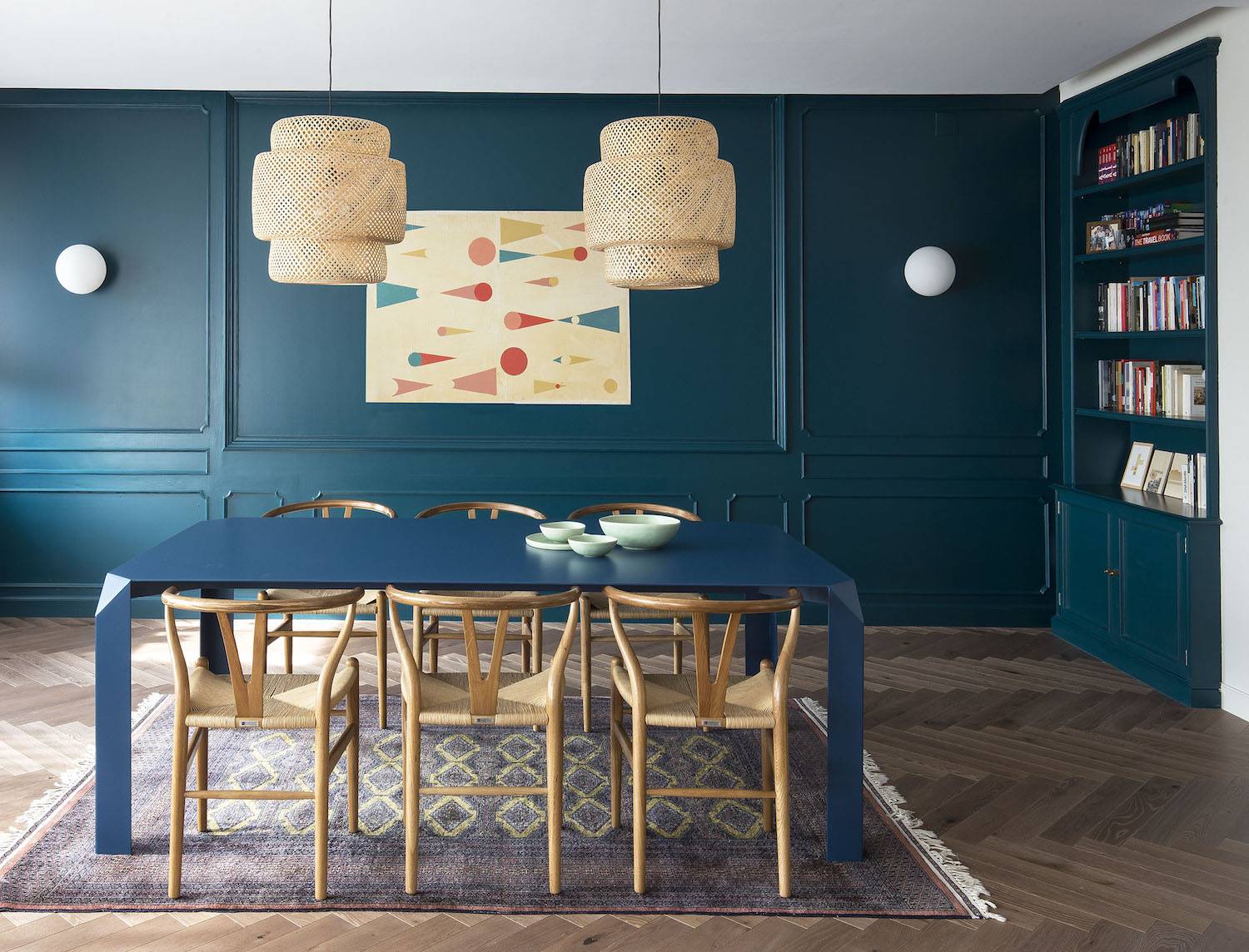 Mesa comedor diseñada por Barbara Aurell para la línea EEB y obra en pared de Regina Giménez.