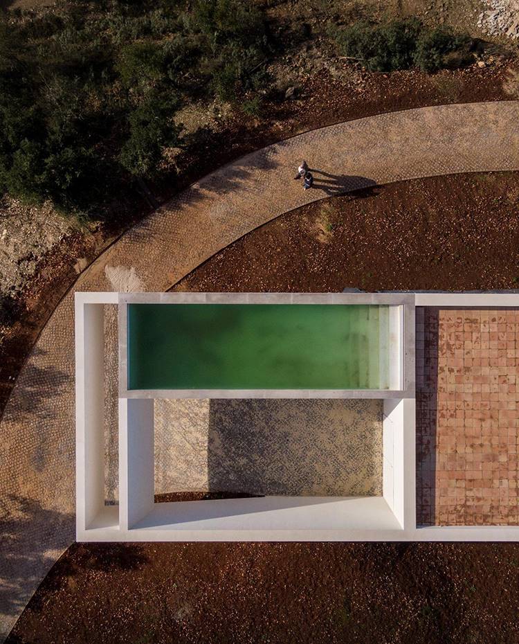 Vista cenital cubierta, piscina en azotea, camino circular, vegetación exterior. En la azotea de la vivienda hay una terraza al aire libre con su piscina en voladizo. Se trata de un espacio al aire libre, ideal para disfrutar del sol y admirar el paisaje de la campiña del extremo sur de Portugal.