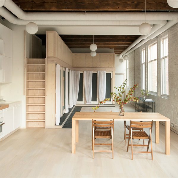 Mesa comedor, sillas plegables madera, escalera vertical, cocina blanca, conductos de aire en blanco, loft industrial