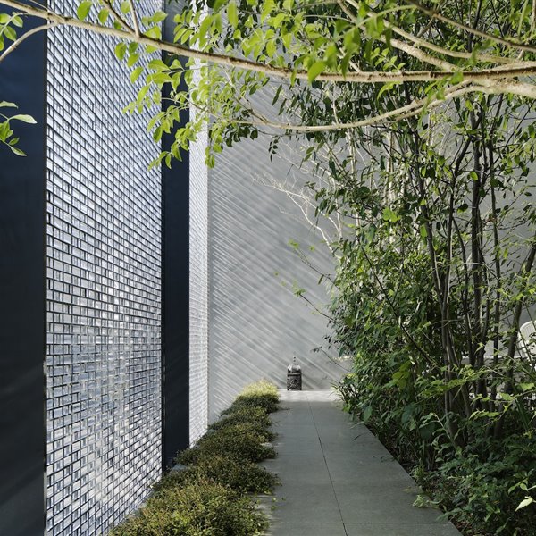 Patio con con iluminación natural que se filtra a través del muro de ladrillos acristalados.